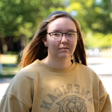 Student standing outdoors looking at camera.